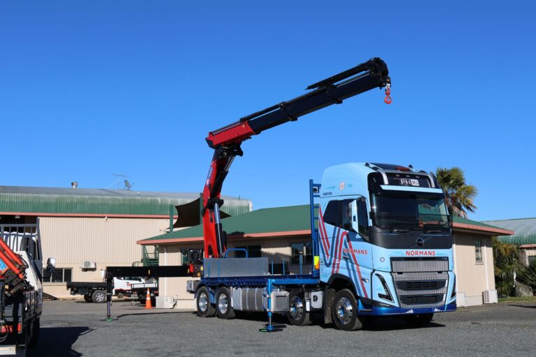Normans Transport Volvo FH16 crane truck with stabiliser legs deployed and HMF 5020 boom raised