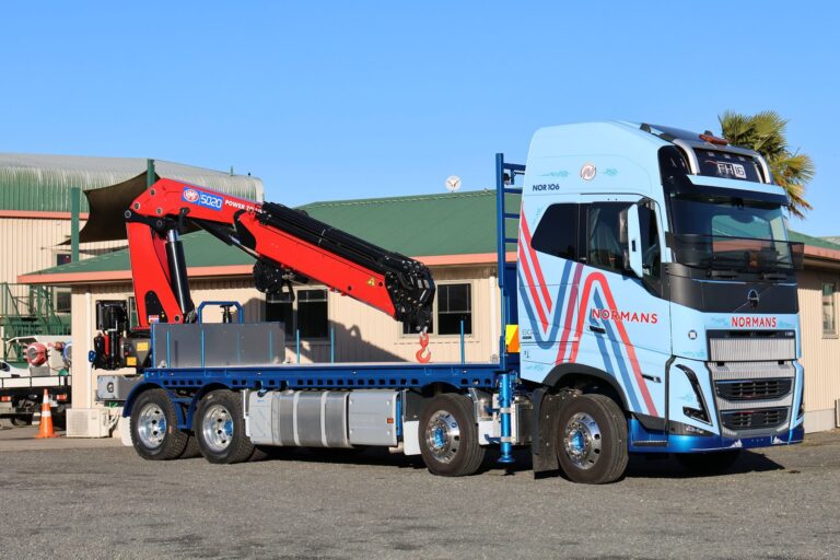Side view of the Normans Transport Volvo FH16 Globetrotter 8x4 with HMF 5020 K6 crane and flat deck